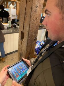 A young man using an electronic tablet to help him order his lunch from a cafe
