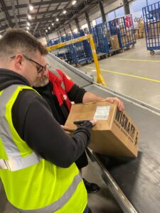 A young man scanning a parcel in a delivery company's warehouse