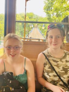Two learners, smiling, while seated on a tram