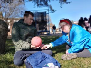 2 people holding hands and holding a ball