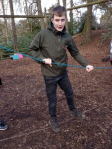 A young man on a low rope assault course