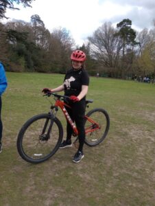 A young woman on a mountain bike in a green field