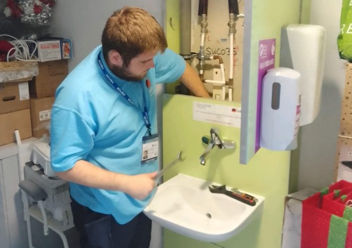 A young man fixing the fittings of a wash basin