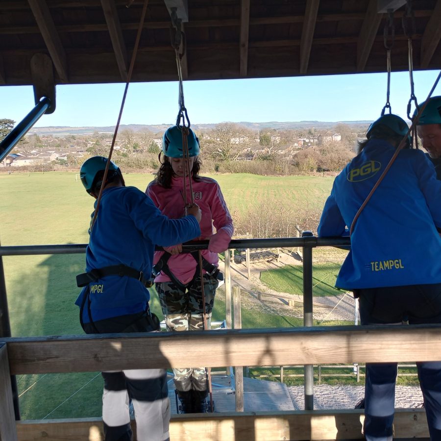 People preparing to go down an abseil wall