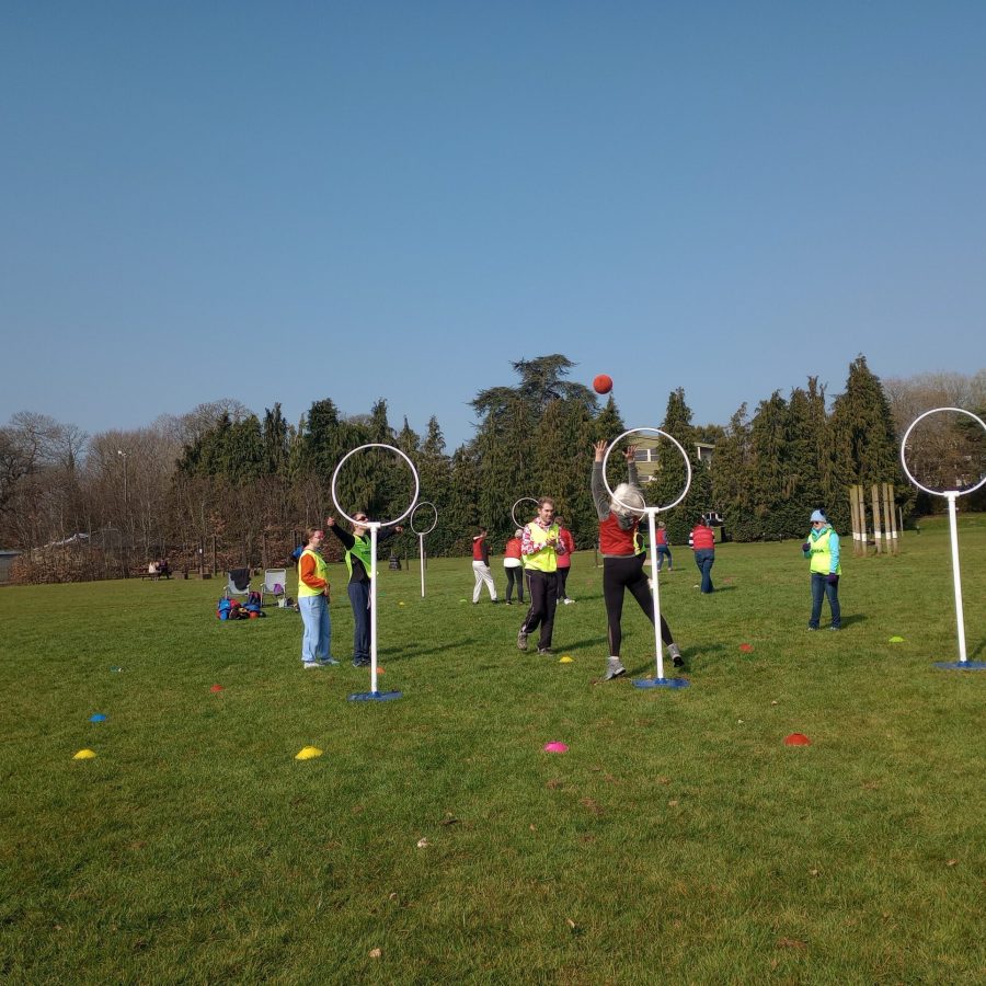 People playing and throwing a ball through rings